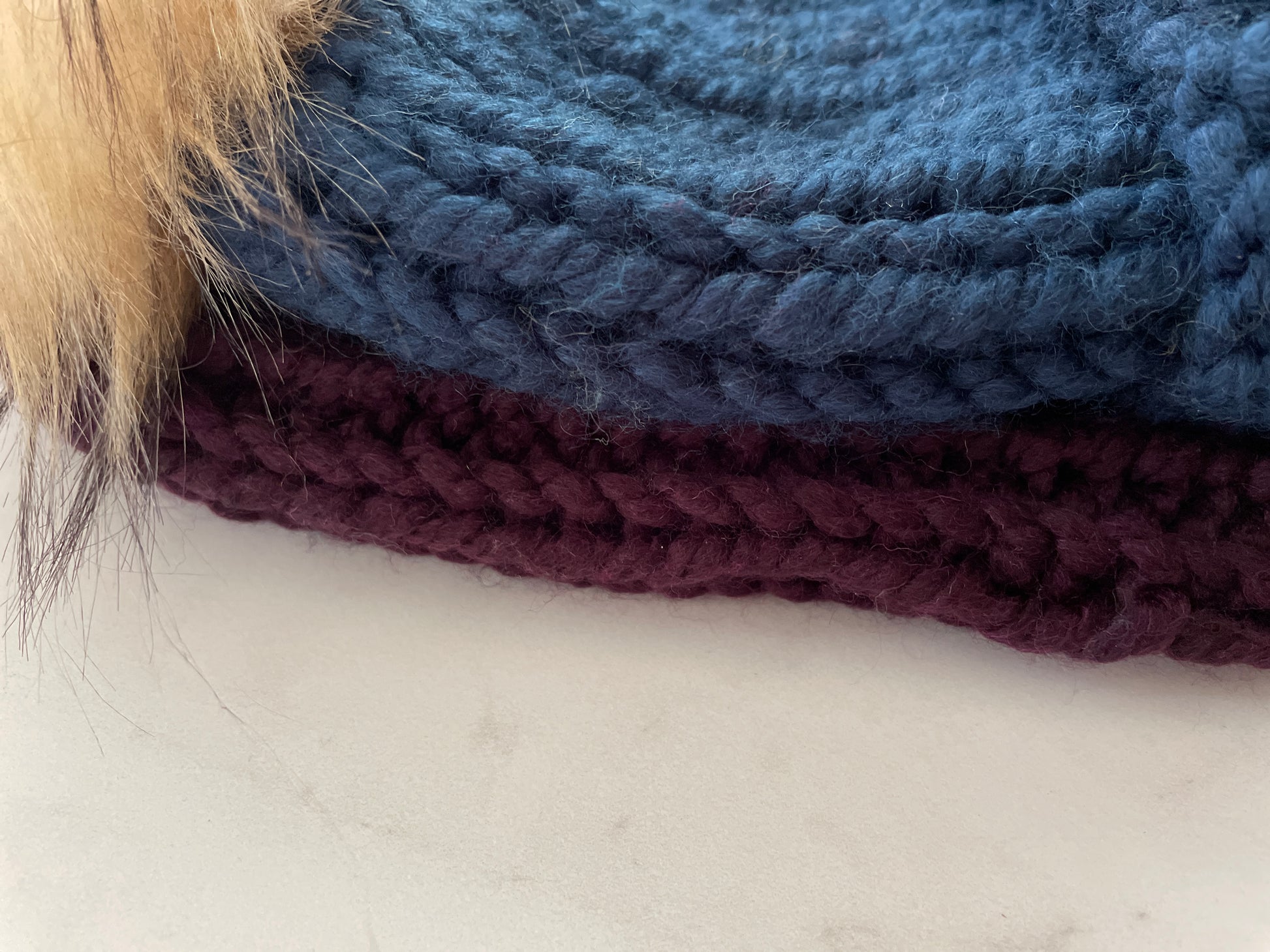 Stack of blue and purple yarn on a white surface