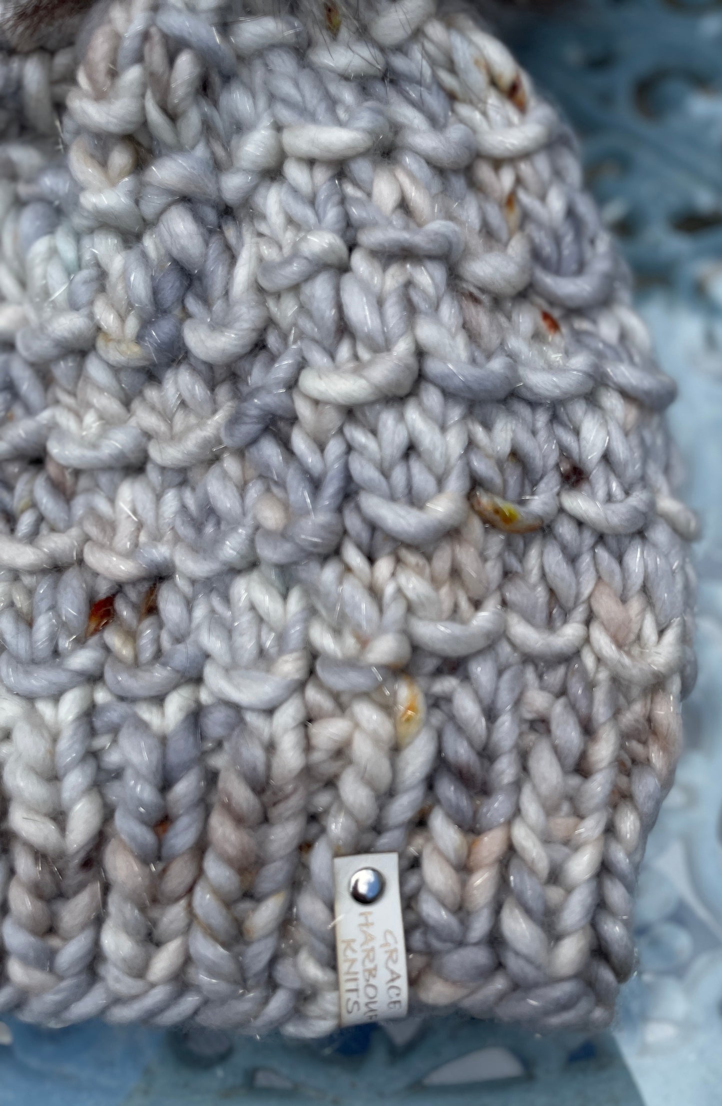 Gray knitted fabric with a brand label on a textured surface