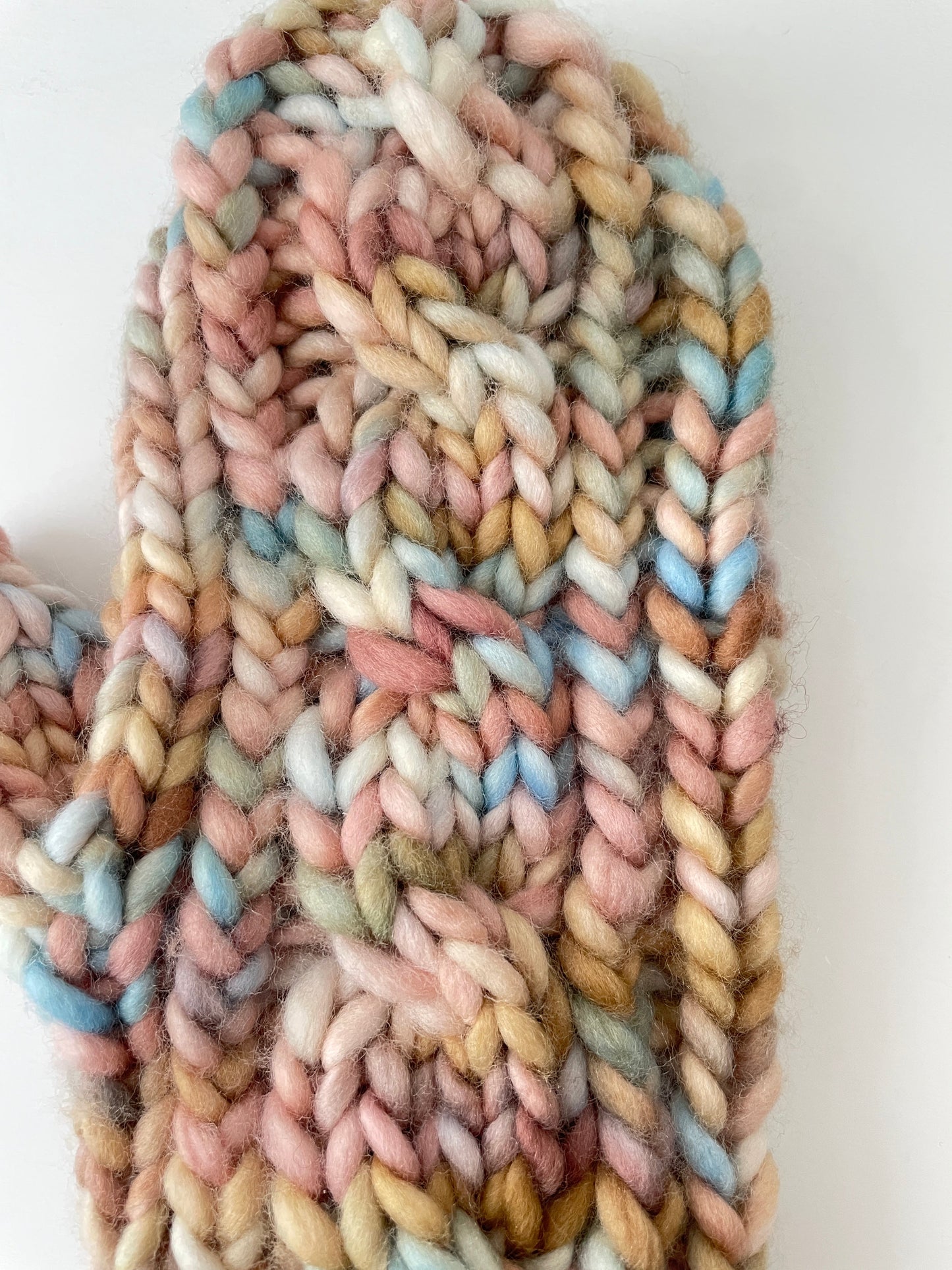 Coiled pastel-colored yarn on a white background