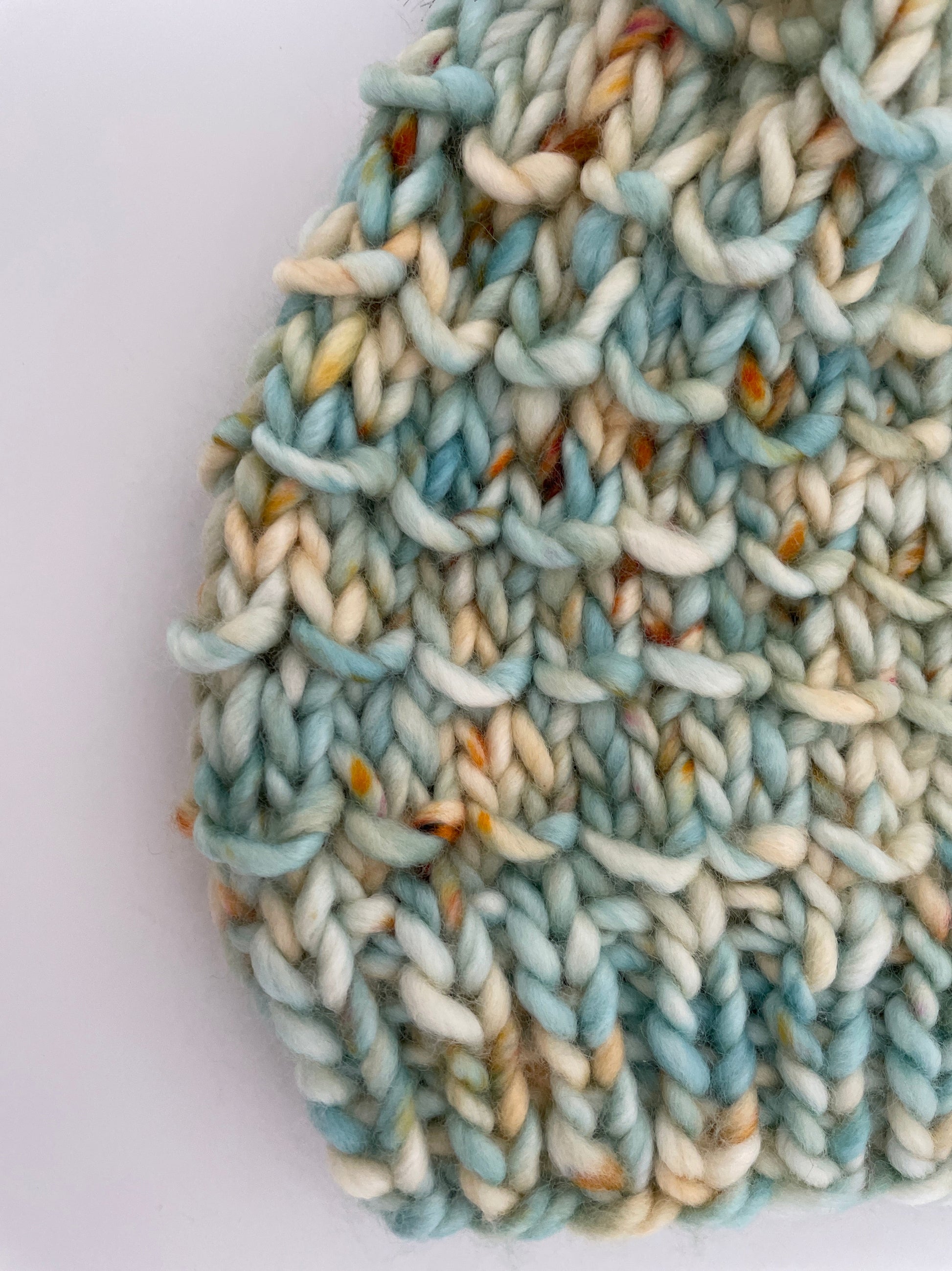Close-up of a knitted fabric with blue and beige colors on a white background