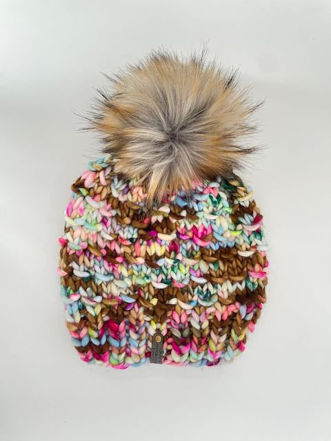 Multicolored knit beanie with a fluffy pom-pom on a white background